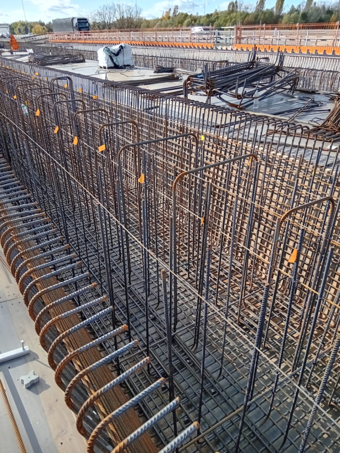 Vorgefertigte Bewehrungskörbe mit Bügeln und Längseisen für Stahlbetonwände auf der Baustelle bereitgestellt